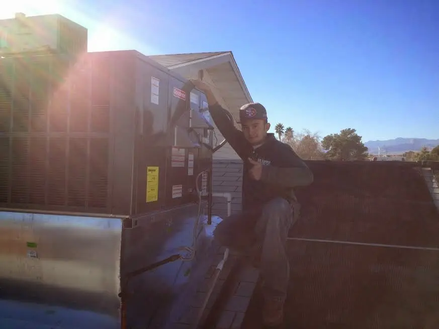 HVAC technician performing HVAC Inspection on a rooftop unit in Delran